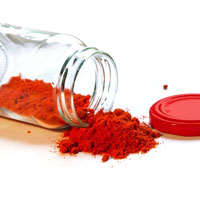 A jar of red powder with no lid that has been tipped over